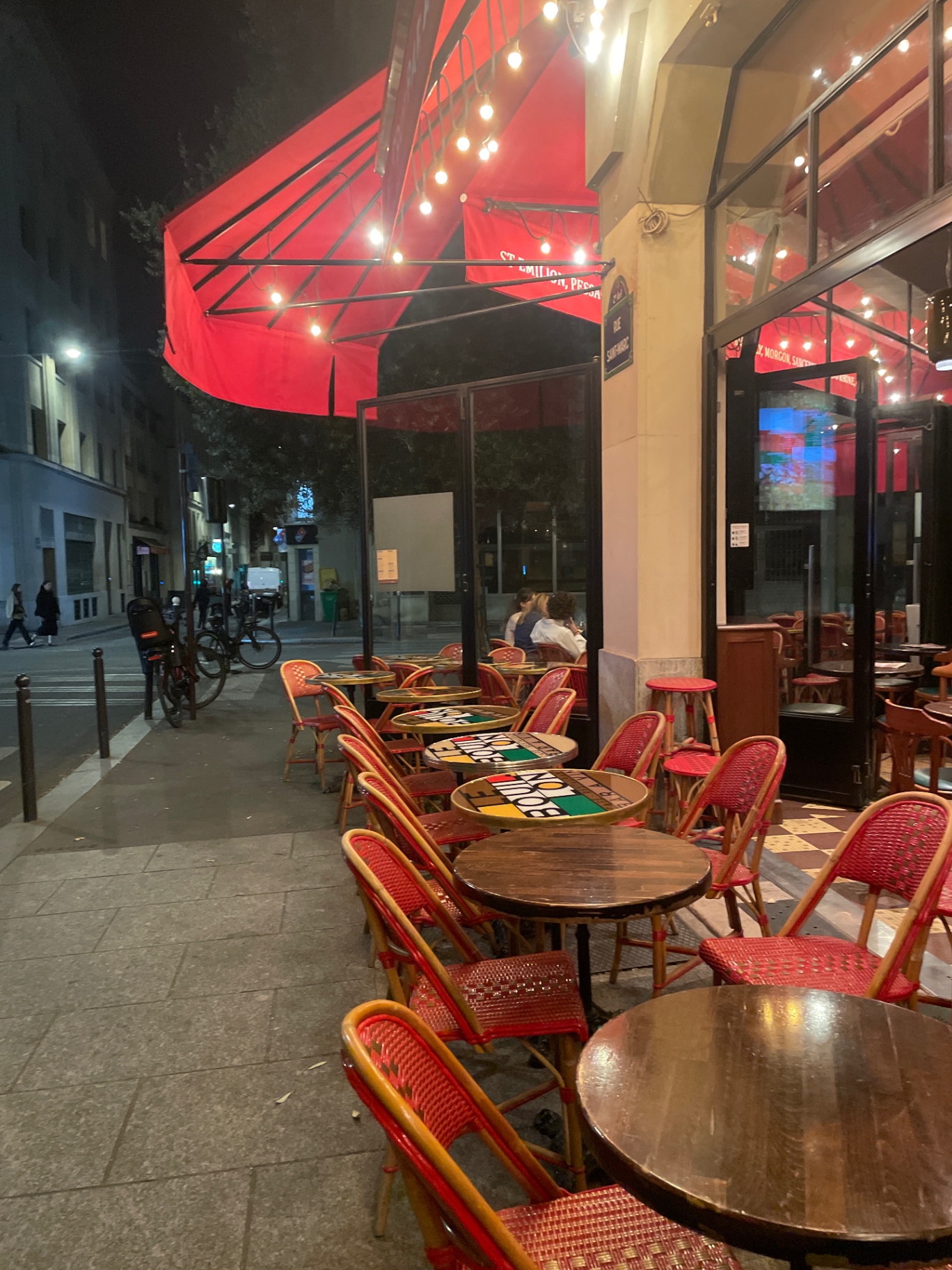 Terrasse du Bouillon le soir, store rouge et guirlandes